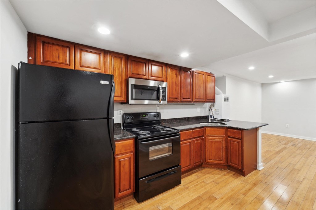 a kitchen with black appliances and wooden cabinets