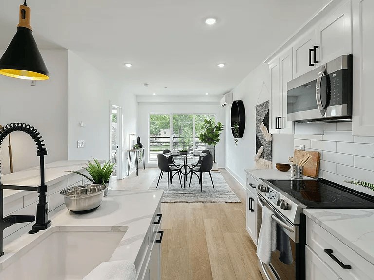 A modern kitchen with white cabinets and a black stove top.