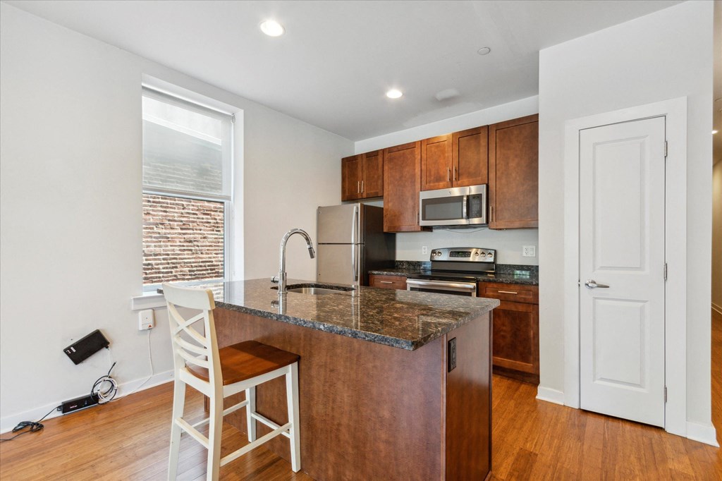 a kitchen with a marble counter top and wooden cabinets