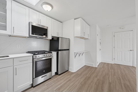 A kitchen with white cabinets and stainless steel appliances.