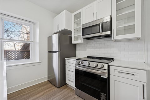 A kitchen with white cabinets and a black stove top oven.