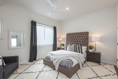 a bedroom with a bed and a ceiling fan