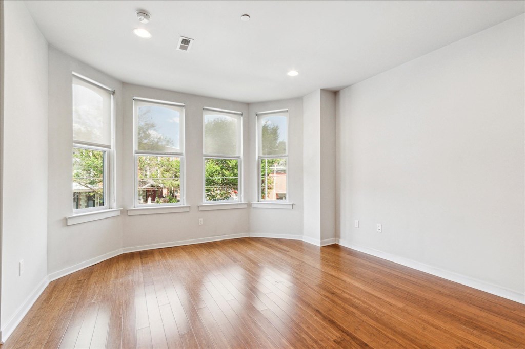 an empty living room with white walls and wood floors