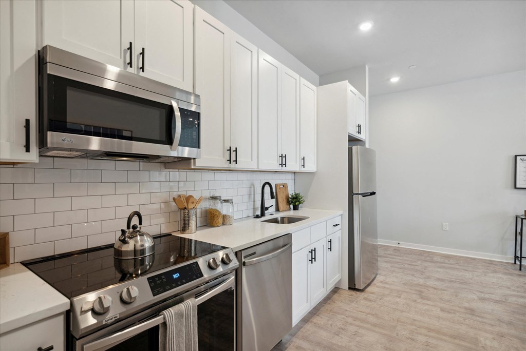 a kitchen with white cabinets and stainless steel appliances