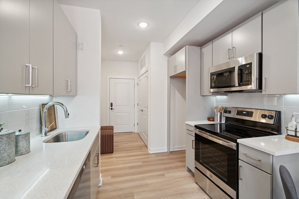 Renovated kitchen with white cabinets and stainless steel appliances at The Anchorage on Kelly, East Falls, Pennsylvania