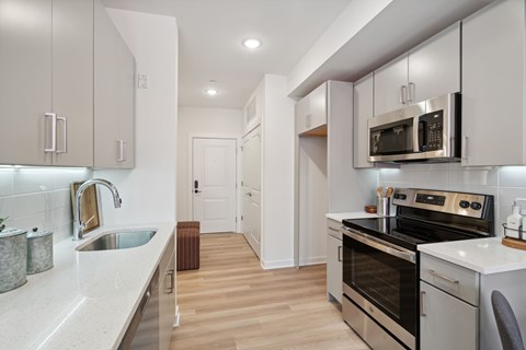 Renovated kitchen with white cabinets and stainless steel appliances at The Anchorage on Kelly, East Falls, Pennsylvania
