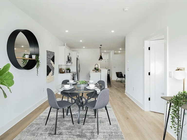 A modern dining room with a glass table and grey chairs.