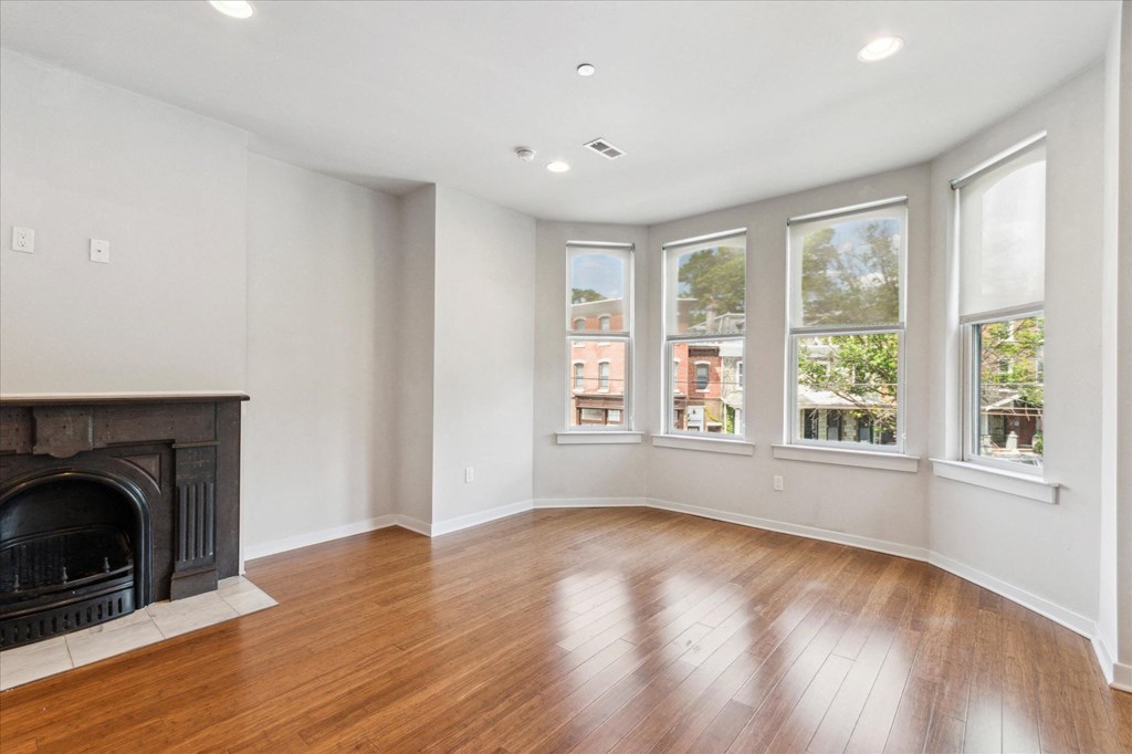 a view of a living room with a fireplace and windows
