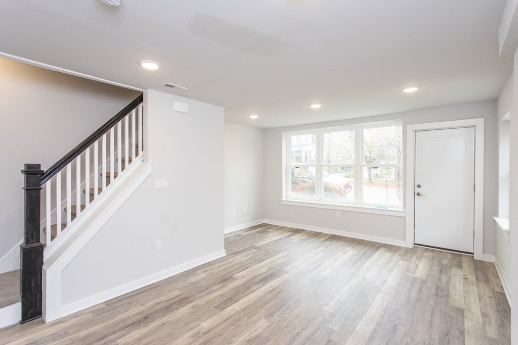 a living room with hardwood floors and white walls