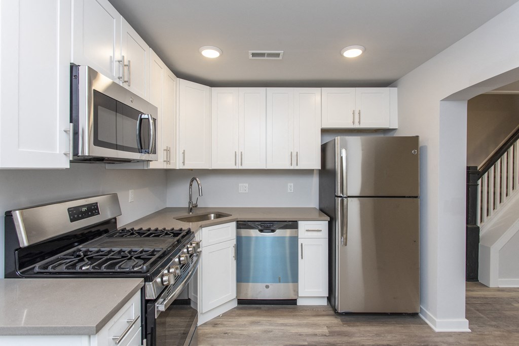 a kitchen with white cabinets and stainless steel appliances