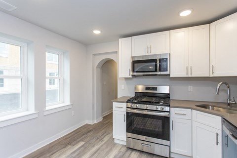 a kitchen with white cabinets and stainless steel appliances