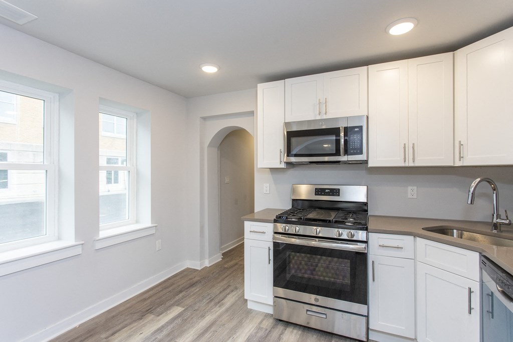 a kitchen with white cabinets and stainless steel appliances