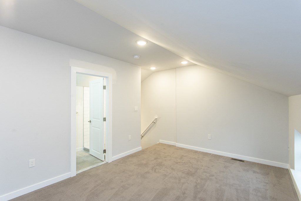 a bedroom with white walls and carpet