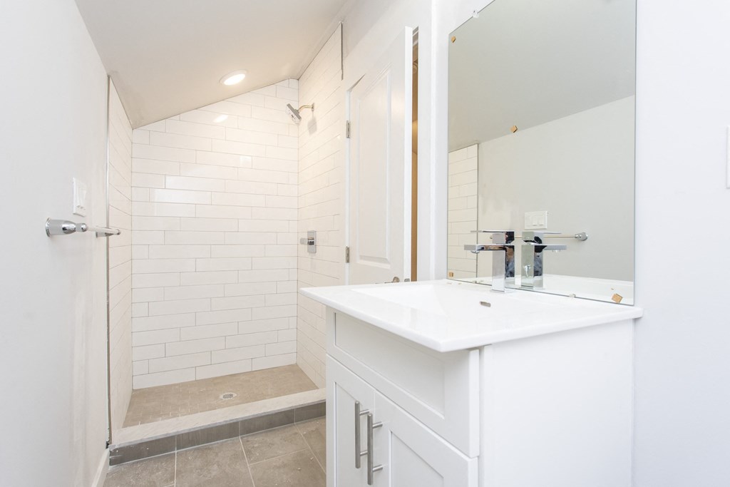 a bathroom with a white sink and a shower with a glass door