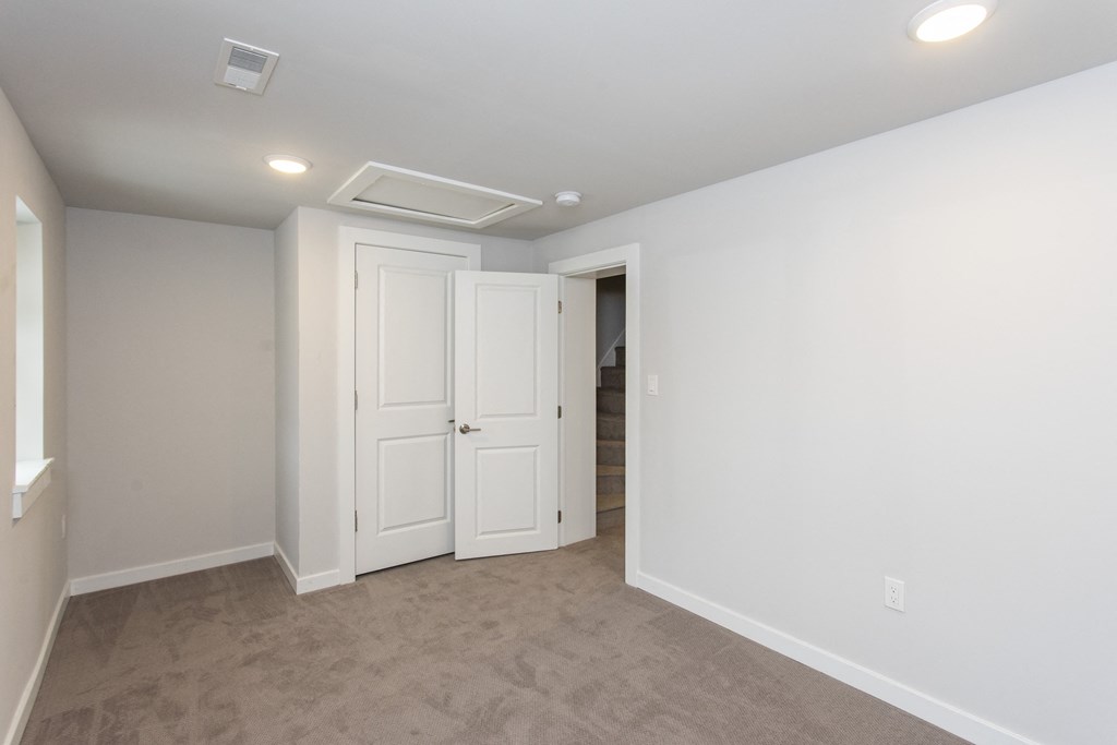 a bedroom with white walls and carpet