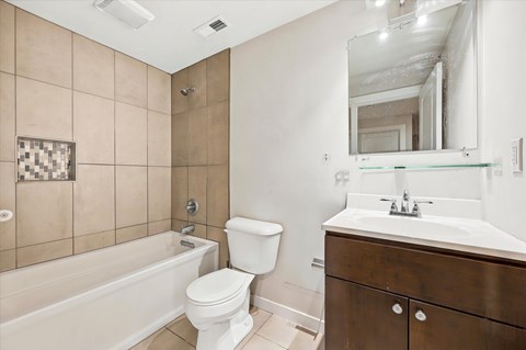A bathroom with a toilet, sink, and bathtub.