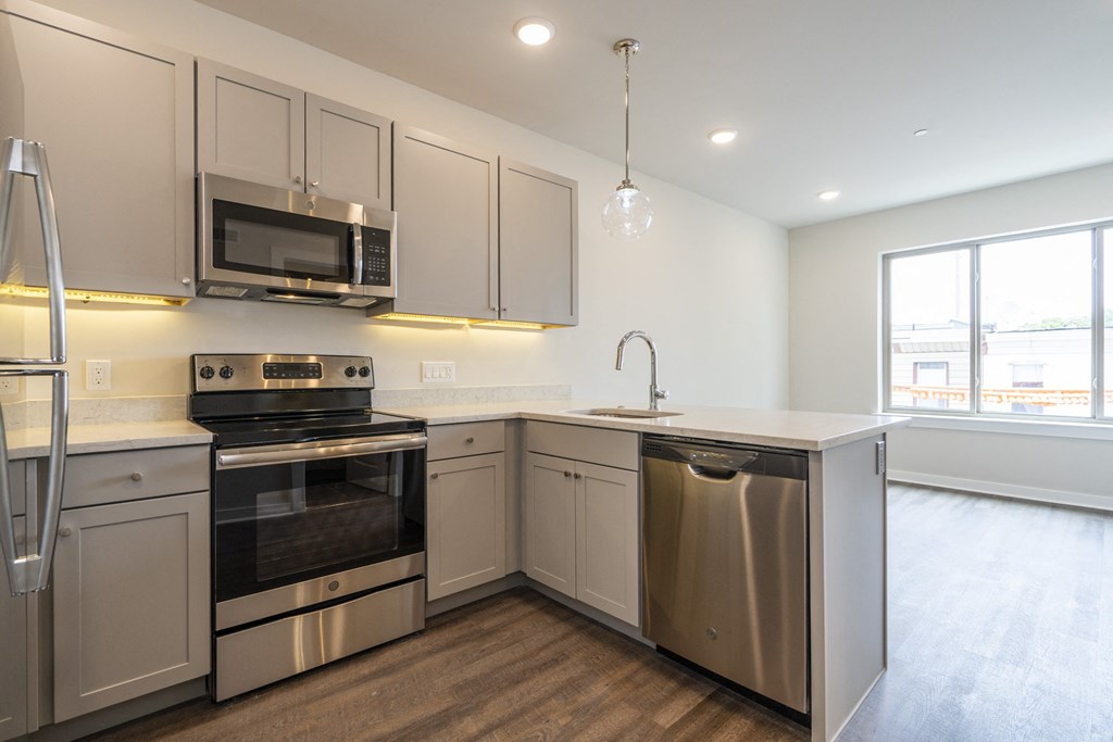 a kitchen with white cabinets and stainless steel appliances