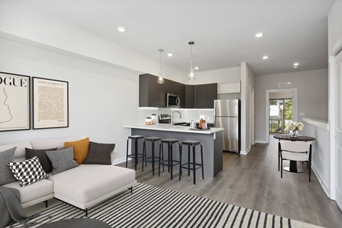 a living room with a couch and a kitchen with a