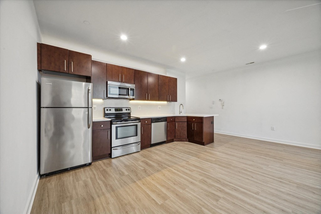 A kitchen with wooden floors and stainless steel appliances.