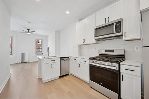 A modern kitchen with white cabinets and stainless steel appliances.