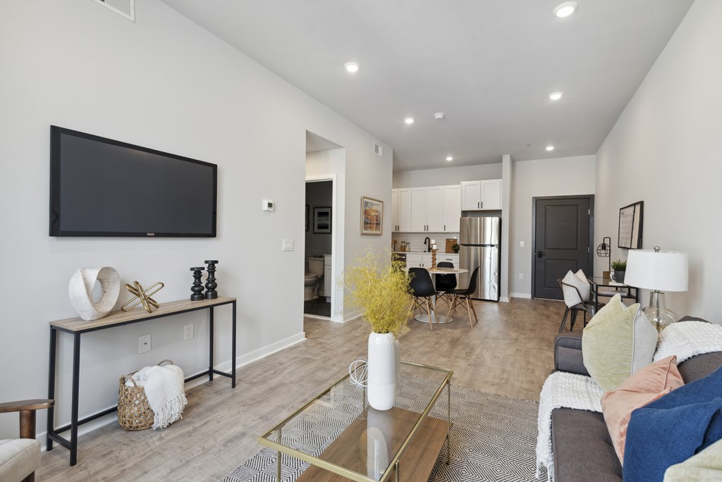 A living room with a couch, a coffee table, and a television.