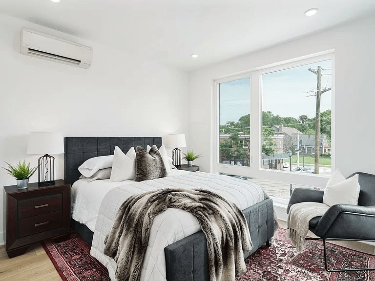 A bedroom with a large bed and a view of the outside.