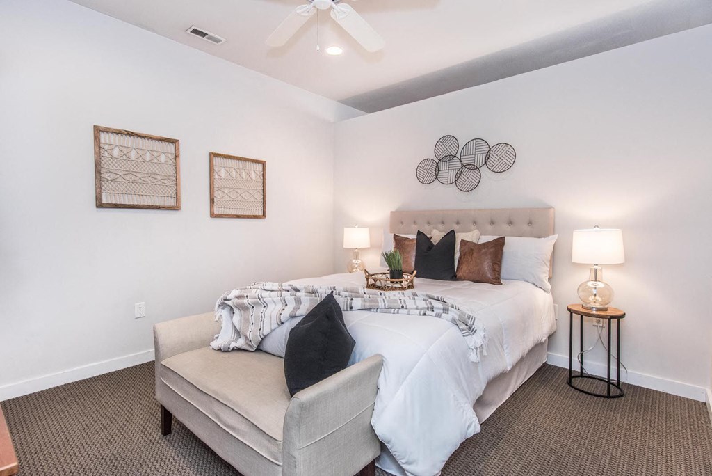 a bedroom with a large bed and a ceiling fan