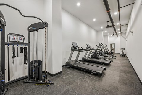 A gym with treadmills, elliptical machines, and other exercise equipment.