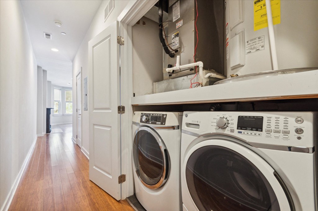 a washer and dryer in a laundry room with a counter and a door
