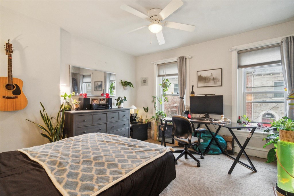 a bedroom with a bed and a desk with a computer