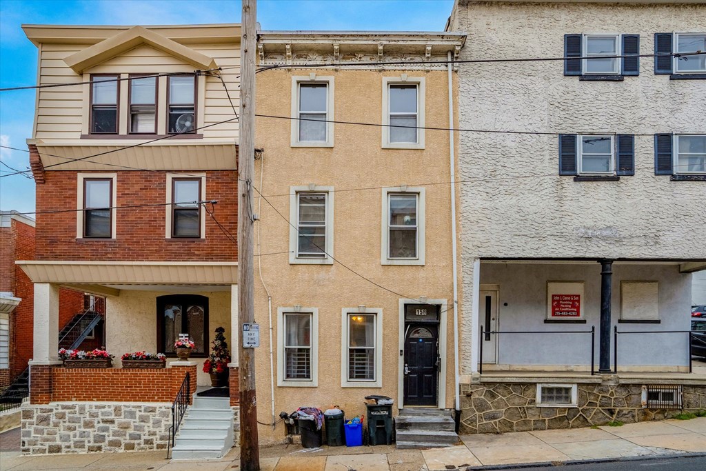 an apartment building with a brick facade and a white house