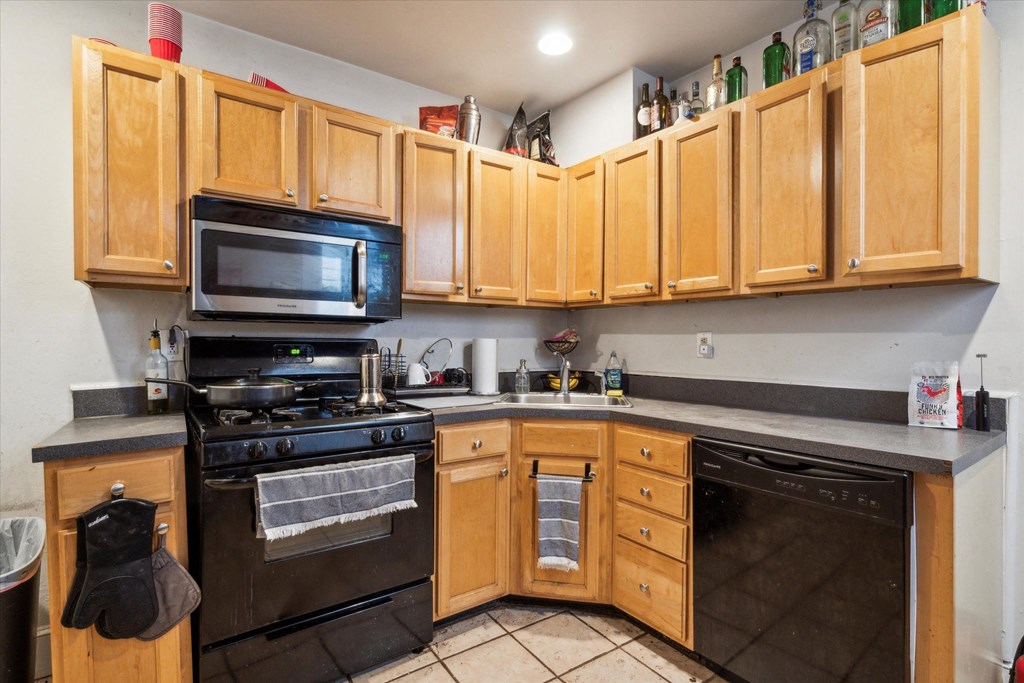 a kitchen with black appliances and wooden cabinets