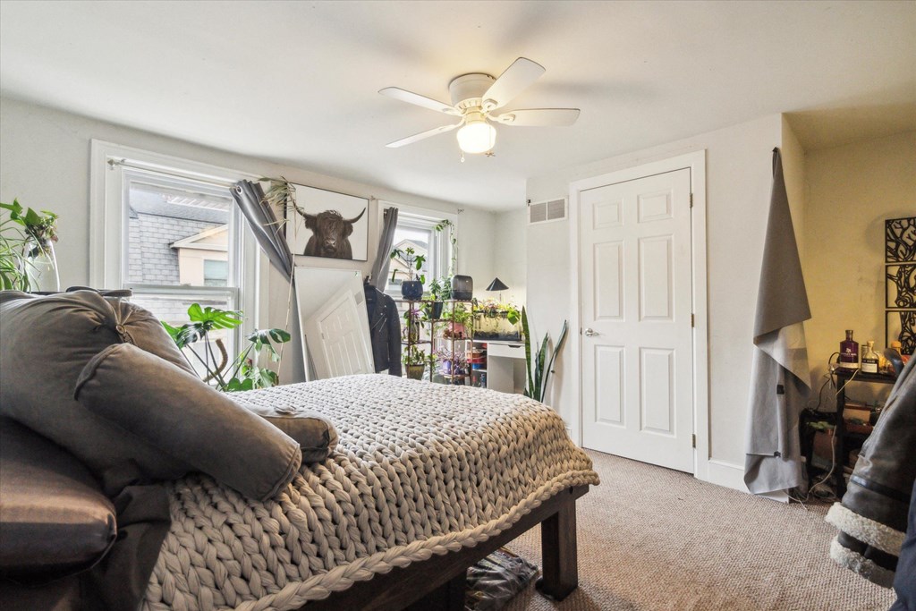 a bedroom with a bed and a ceiling fan