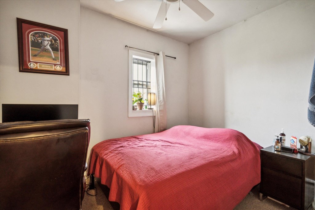 a bedroom with a red bed and a window