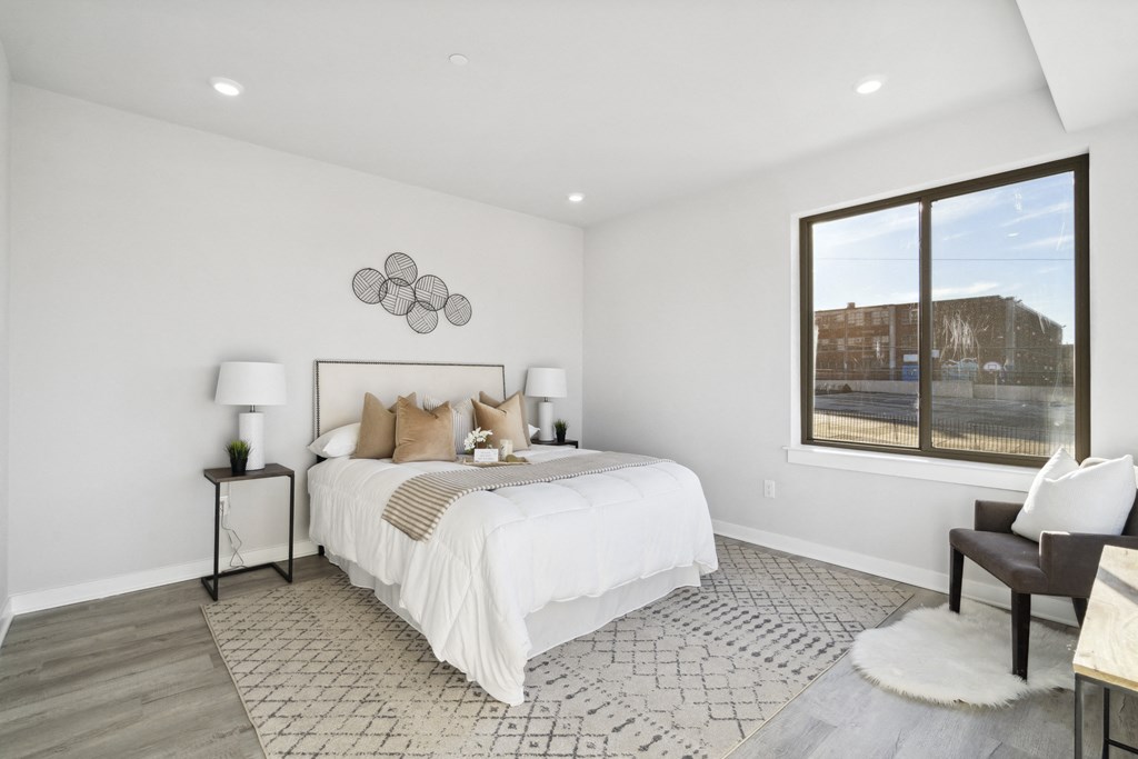 a white bedroom with a large bed and a large window