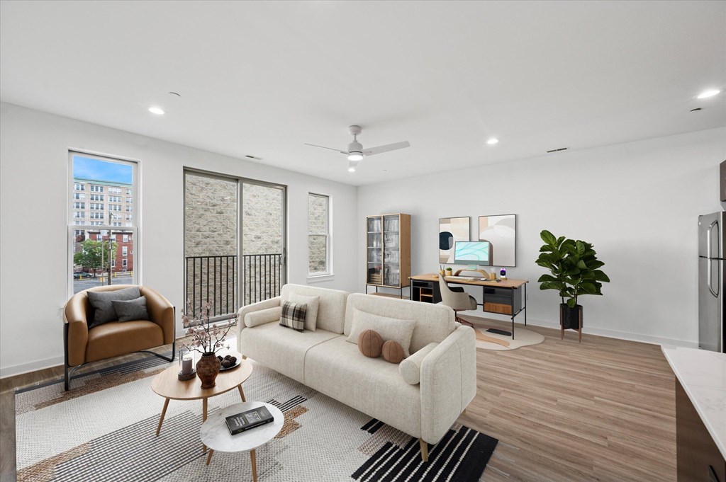 A modern living room with a white couch, a brown chair, and a coffee table.