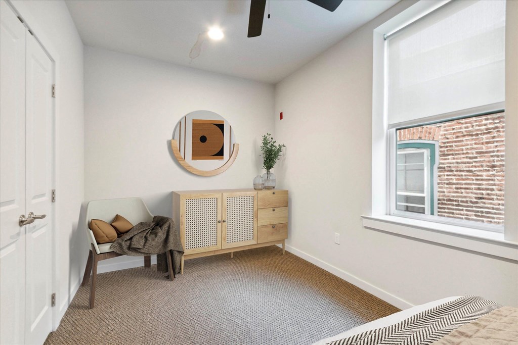 a bedroom with a chair and a window