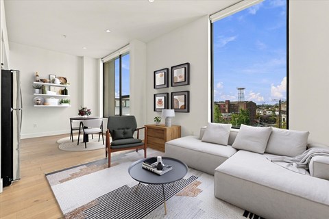 A modern living room with a grey sofa, a black chair, and a coffee table.