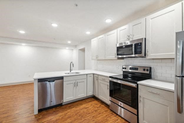 a kitchen with white cabinets and stainless steel appliances