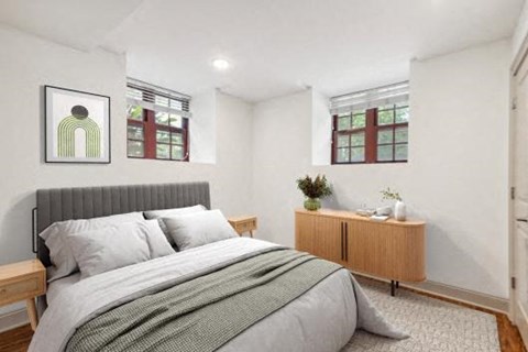 a bedroom with a bed and two windows
