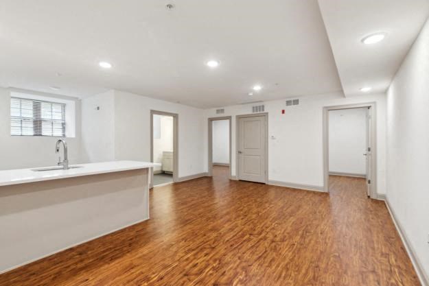 a kitchen and living room with a wooden floor