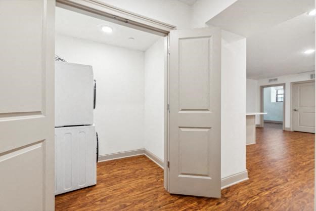 a room with a white refrigerator and a wooden floor