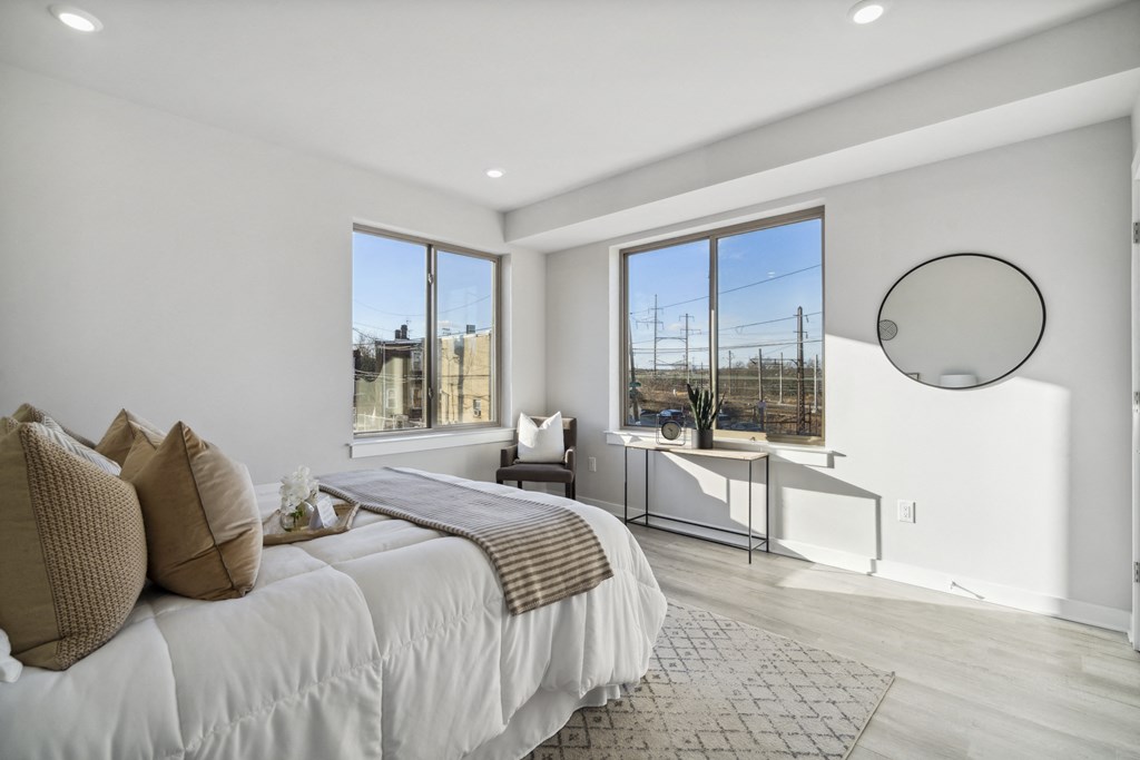 a white bedroom with a large bed and a window