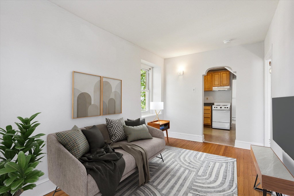 A living room with a couch and a painting on the wall.