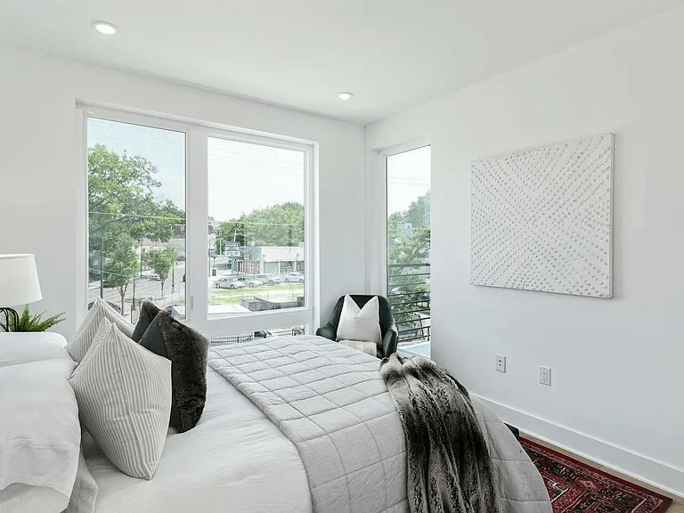 A bedroom with a large bed and a view of the outside.