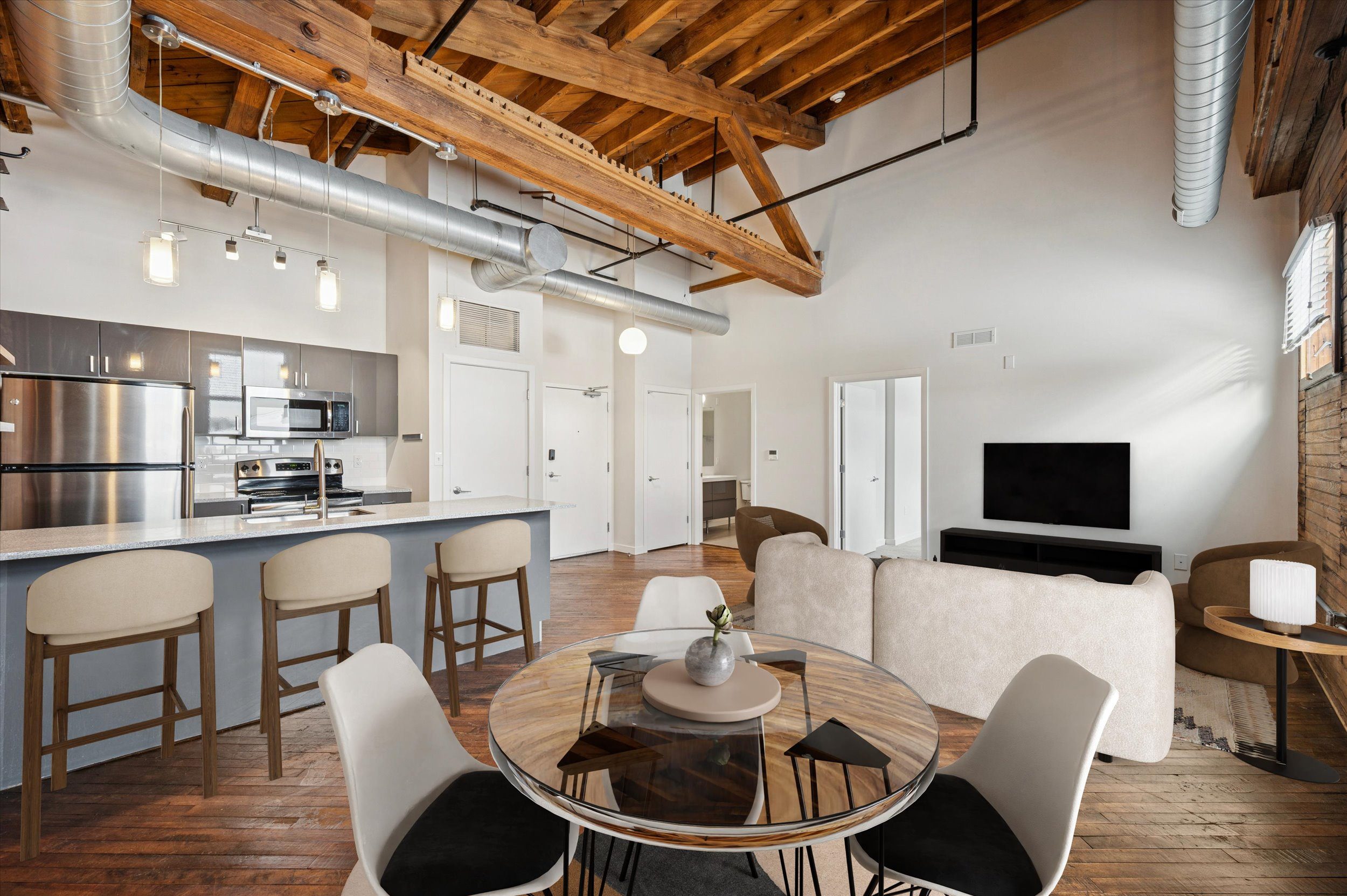 A modern open plan living and kitchen area with a dining table and chairs.