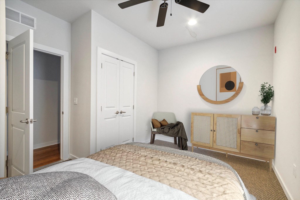 a bedroom with a large bed and a ceiling fan