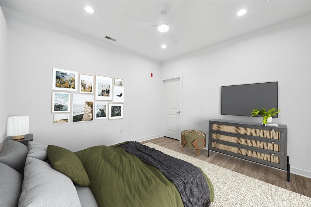 A bedroom with a bed, a dresser, and pictures on the wall.