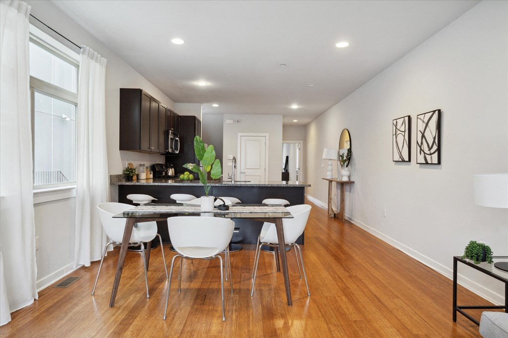a dining room with a table and chairs in front of a kitchen