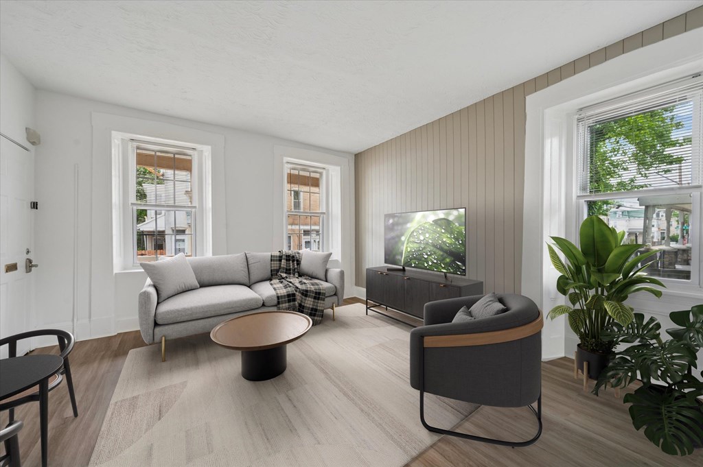 A living room with a grey couch, a black chair, and a coffee table.